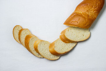 Sliced baguette on a white tablecloth. Bakery product. Delicious bread