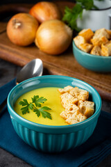 Bowl with onion soup and croutons on the table.