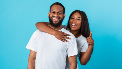 Fototapeta premium Happy afro couple gesturing thumbs up and smiling