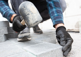 Worker lining paving slabs path