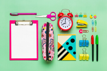  Frame from of office supplies Paper clips, scissors, pens, felt-tip pens, sharpener, calculator, stapler isolated on green background Flat lay Top view Back to school, education concept