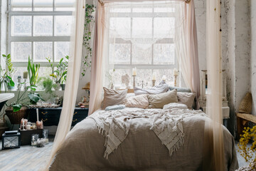 Cozy boho chic bedroom decorated with green plants © brizmaker