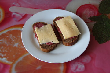 Two black bread sandwiches with salami and cheese
