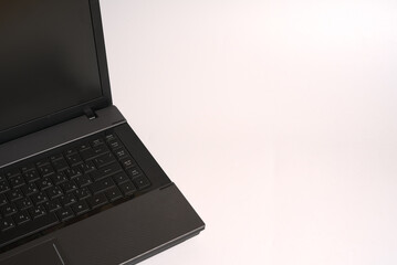 Black and gray laptop on a white background. Close. Space for text