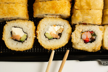 sushi set in an open black plastic bag with two chopsticks. White background