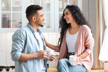 Fototapeta premium Loving Middle Eastern Couple Bonding While Drinking Coffee In Kitchen
