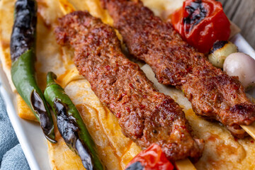 Traditional delicious Turkish food; Adana kebab while cooking on a barbecue