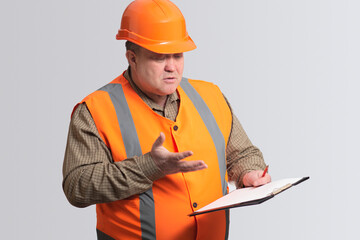 middle-aged fat engineer in hard hat, funny disgruntled foreman on a gray isolated background, emotions on face