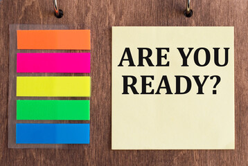 Are You Ready lettering on yellow note paper on wooden background