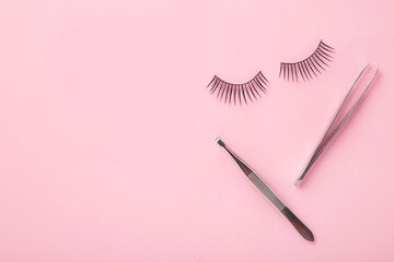 Set of false eyelashes extencions on pink background with tweezers. Minimalism