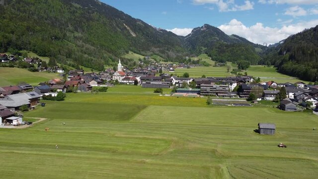 Flug mit der Drohne &uuml;ber Wiesen und Weiden rund um Bezau im Bregenzerwald zur Heuernte im Fr&uuml;hling