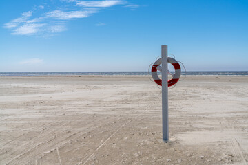 rescue station and flotation ring on an endless sandy beach on the Wadden Sea island coast of...