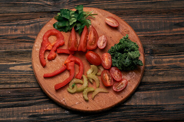 sliced vegetables on a round wooden board.