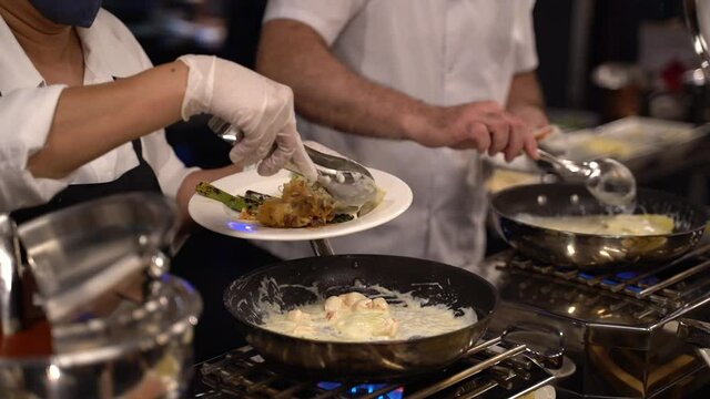 Chef preparando variedad de platos en un buffet
