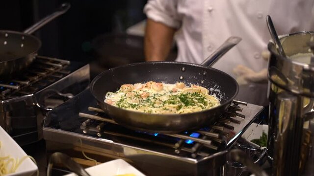 Chef preparando variedad de platos en un buffet