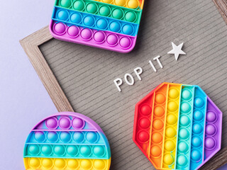 Pop it fidget toys to help reduce stress and anxiety in kids and adults and letter board - obrazy, fototapety, plakaty