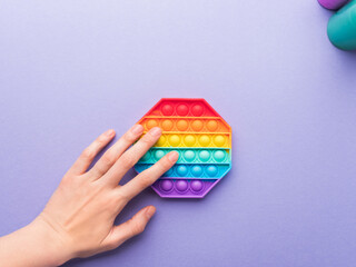 Pop it fidget toys to reduce stress and anxiety in kids and adults, hand pushing a bubble