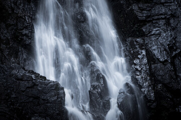 A large waterfall flows through the rocks.