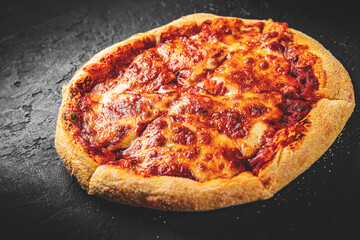 sliced Pizza with Mozzarella cheese, Tomatoes, pepper, Spices. Italian pizza. Pizza Margherita or Margarita on Dark grey black slate background