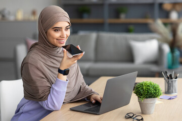 Muslim woman using voice search assistant on smart phone