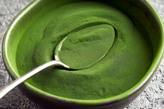 Green Chlorella Algae Powder In A Dark Bowl