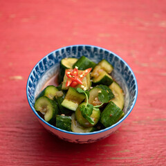 Orient salad of fresh cucumbers and greens. Pan-Asian cuisine, vegetable dishes. Vegetarian healthy food. Vitamin dish of spring season. Soft focus.