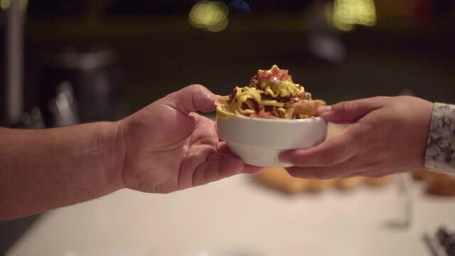 chef entrega ensalada mexicana a comensal en una fiesta de bodas lujosa