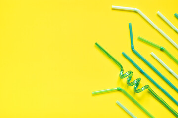 plastic drinks tubes on a yellow background with space for text