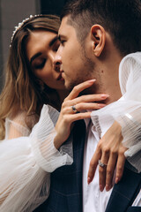 The faces of the bride and groom. Portrait of the newlyweds. Young hugs.