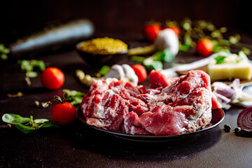 Fresh pork with vegetables on dark background. Fresh meat kitchen