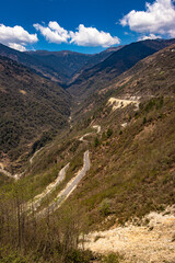 mountain valley with curvy road and bright blue sky at sunny day