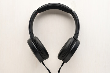Black wired Headphones on gray wooden background. Entertainment concept