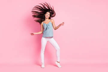 Full length photo of cheerful nice pretty young lady fly hair good mood dance isolated on pink color background