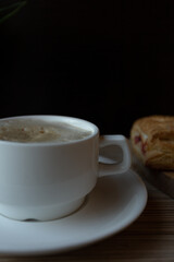 a cup of coffee and a cake on a black background