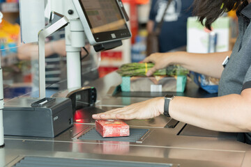 Supermarket cashier scanning items.