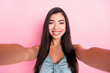 Fototapeta premium Self-portrait of attractive cheerful woman wearing pin-up summer top isolated over pink pastel color background