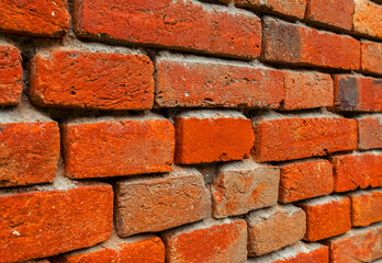 Obraz premium Wall of old red brick with weathered cement. At an angle