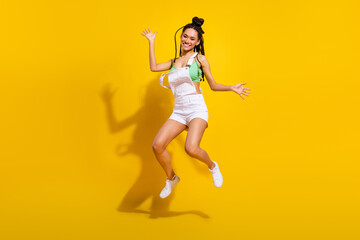 Full body photo of afro american active young woman jump up air smile isolated on yellow color background