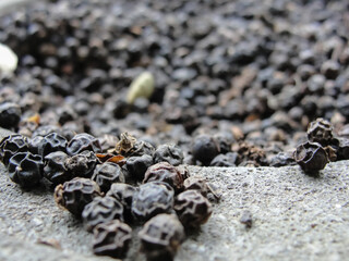 Black pepper peas in stone mortar, selective focus