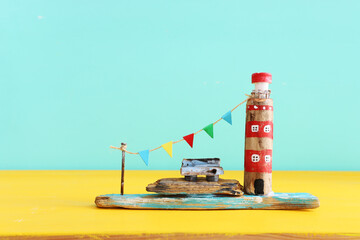 nautical concept with driftwood beach houses and lighthouse over wooden table