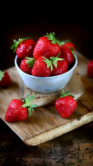 Fresh strawberries in a bowl on a dark background.