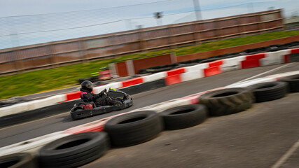 A panning shot of a racing kart as it circuits a track.
