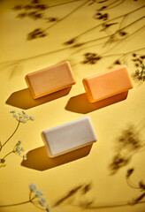 the product still of the soap on yellow background with the floral shadows
