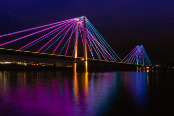 Fototapeta na wymiar Artistic night view on colorful illuminated of suspension bridge in Krasnoyarsk, Russia