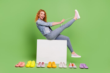 Full length profile side photo of young girl happy positive smile shop fitting shoes laces customer...