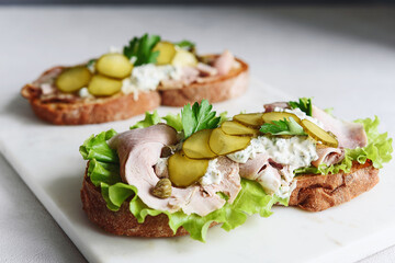 Cold baked pork, pickle and lettuce with remoulade (danish tartar sauce) Smorrebrod. Danish open faced sandwich. Selective focus - 437075052