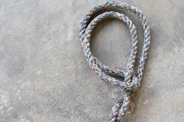 Ship ropes tied to knot, isolated on cement flooring background closeup.