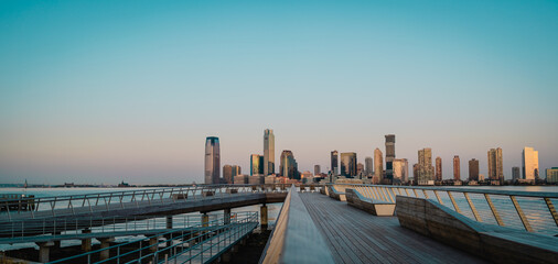 Obraz premium pier at sunrise New York City horizon New Jersey urban river architecture 