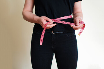 Woman measuring her waistline fat tummy. Concept of the diet, the body measures, body part of a fat woman with measuring tape