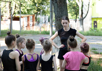 Coach talking with her trainees on training on sports playground